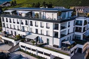 Un hotel de diverses plantes amb balcons, un terrat pla i un estil arquitectònic modern.