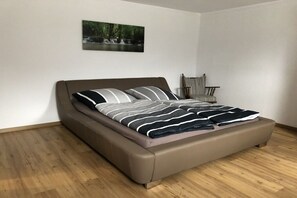 A modern bedroom with a bed, a chair, and a picture on the wall. - Holiday apartment with 1 bedroom (Schönau am Königssee)