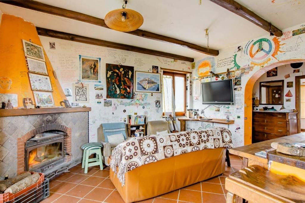 Ein gemütliches Wohnzimmer mit Kamin, einer Couch, einem Fernseher und verschiedenen Wanddekorationen.