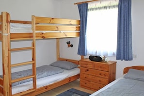 A bunk bed room with a wooden dresser and a window with curtains. - Holiday home in Allgäu with 2 bedrooms (Lechbruck)