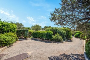 A gravel driveway leading to a building with a metal door labeled 'STELLA.' - Casa Molara (San Teodoro)