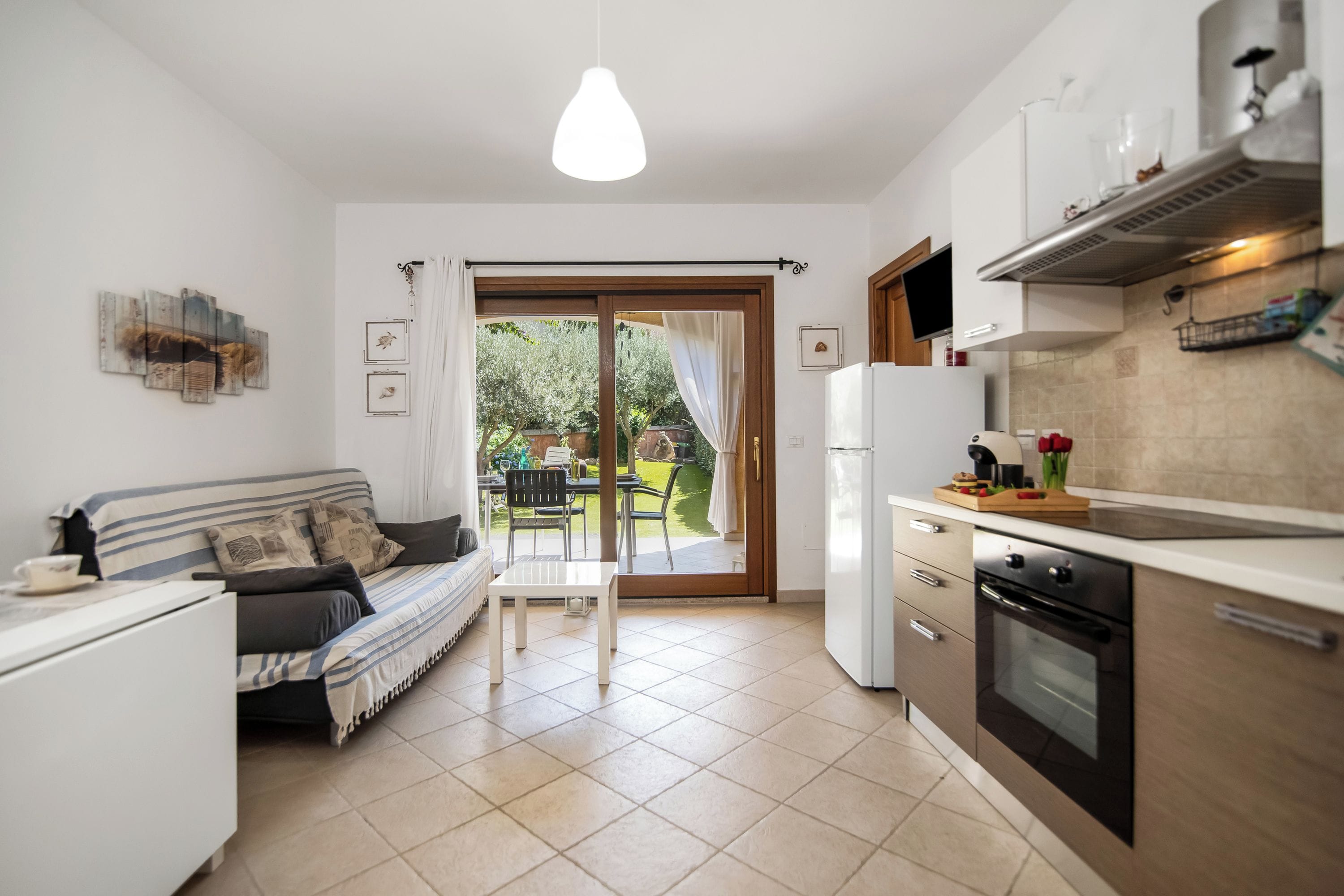 Una cucina moderna con zona pranzo, divano e vista sull'esterno.