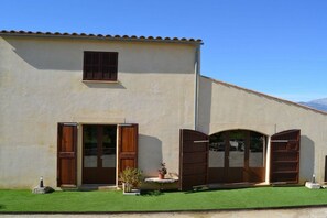A building with a flat roof, a small window, and a door with a wooden shutter. - Finca in Muro with swimming pool (Muro)