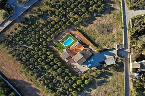 An aerial view of a property with a swimming pool, a tennis court, and a large house with a sloped roof. - Finca in Muro with swimming pool (Muro)