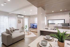 Ein modernes Wohnzimmer mit einer Couch, einem Couchtisch und einem Fernseher.