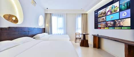 Habitación de hotel con dos camas, una pared con televisor y una mesita.