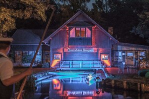 Edifici de fusta amb un rètol que diu 'Doorhaus Raupen' de nit.