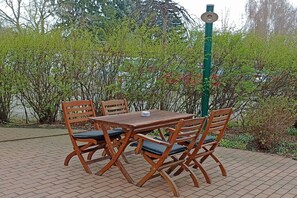 An outdoor seating area with a table and chairs, surrounded by greenery. - "To the Harbor Master No. 1" (Lübbenau\/Spreewald)