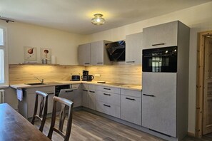 A modern kitchen with a built-in oven, a coffee maker, and a sink. - "To the Harbor Master No. 1" (Lübbenau\/Spreewald)