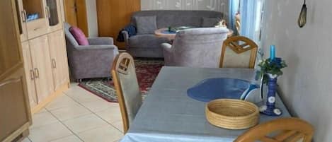 Un comedor con una mesa, sillas y un sofá al fondo.