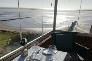 Mesa dispuesta para comer con vista al océano.