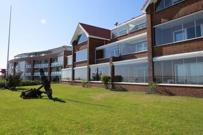 A multi-story building with large windows and a brick facade. - Holiday apartment with 2 bedrooms (Wittdün)