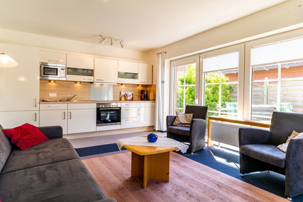 Ein stilvoller Wohnraum mit Sofa, Couchtisch und Blick ins Freie.