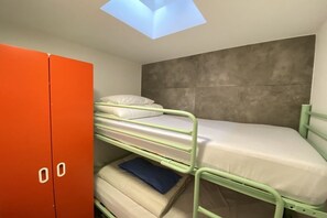 A bunk bed with a skylight above, a wardrobe, and a grey textured wall. - Bungalow with 1 bedroom (Callantsoog)