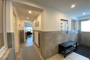 A hallway with a bench, a radiator, and a door leading to another room. - Bungalow with 1 bedroom (Callantsoog)