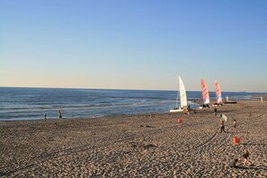 A beach with multiple windsurfing boards and a clear sky. - Bungalow with 1 bedroom (Callantsoog)