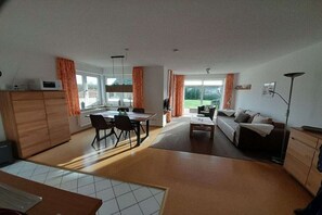 Un vaste espace de vie comprenant une table à manger, un canapé et une vue sur l’extérieur.