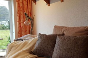 Une chambre à coucher avec un lit, une fenêtre avec des rideaux et une vue sur l’extérieur.