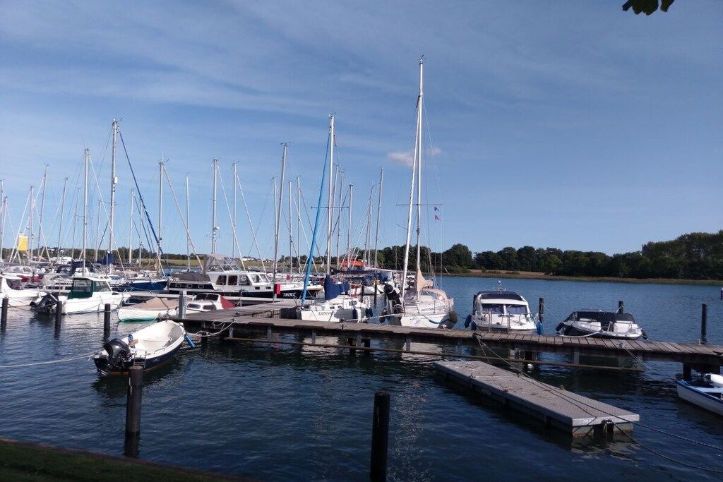 Un port de plaisance où sont amarrés différents types de bateaux, notamment des voiliers et des bateaux à moteur.
