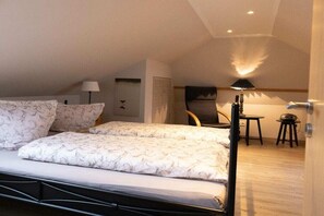 A bedroom with a bed, two bedside tables, a chair, and a desk with a lamp. - Holiday home with 2 bedrooms (Simonsberg)