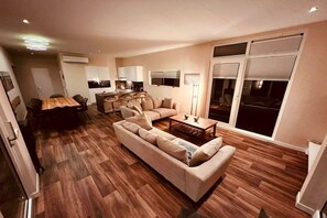 A modern living room with a sofa, coffee table, and dining area. - Holiday home with 2 bedrooms (Ribnitz-Damgarten)