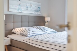 Een hotelkamer met een bed, een hoofdeinde, een wanddecoratie en een bedlamp.