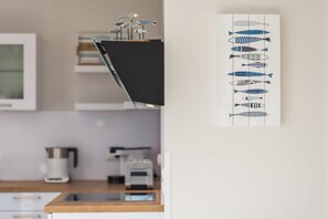 A kitchen with a modern design, featuring a black countertop, a coffee maker, and a toaster. - Holiday apartment with 1 bedroom (Zingst)