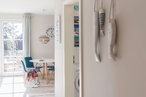 A modern kitchen with a dining area, a large window, and hanging utensils. - Holiday apartment with 1 bedroom (Zingst)