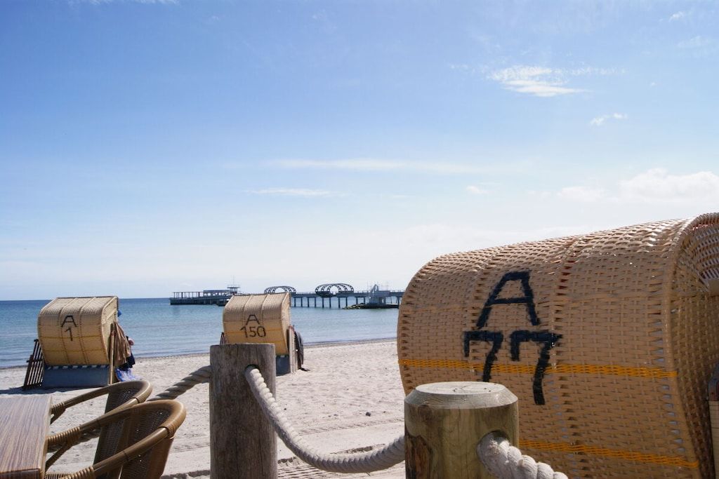 Une vue sur la plage, avec des chaises de plage et un poteau en bois muni d’une corde.