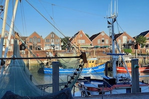 Ein Hafen mit Booten, einem Fischernetz und Gebäuden im Hintergrund.