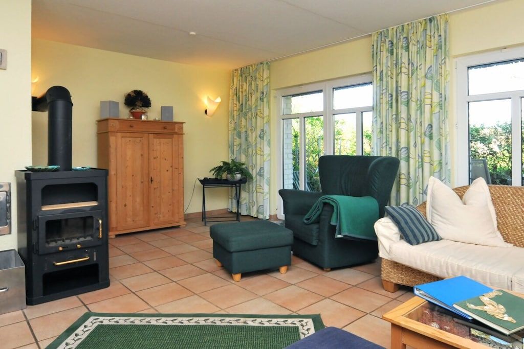 Ein Wohnzimmer mit einer Couch, einem Hocker und einem Kamin.
