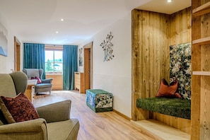 Ein modernes Wohnzimmer mit einer Couch, einer Wand mit Holzpaneelen und einem Fenster mit Vorhängen.
