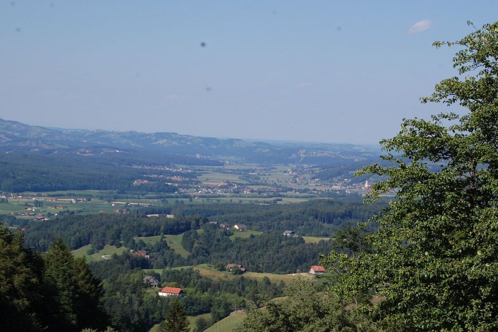 A panoramic view of a hilly landscape with scattered houses and a clear sky.