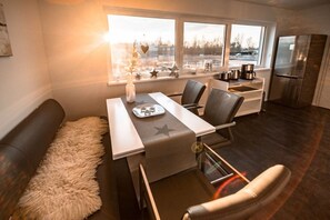 A modern kitchen with a dining area, large windows, and a refrigerator. - Holiday home with 2 bedrooms (Bitterfeld)