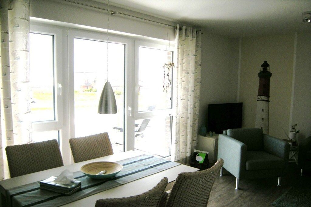 A dining area with a table, chairs, and a television.