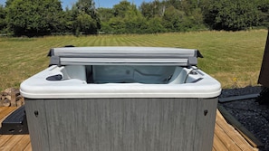 A hot tub on a wooden deck with a grassy yard in the background. - Killymoon Lodge – Luxury Adults-Only Escape with Private Hot Tub (Newport)