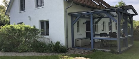 A house with a glass conservatory attached to the main building.
