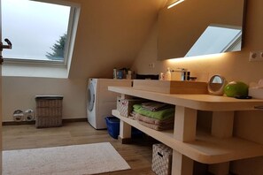 A laundry room with a washing machine, a drying rack, and a shelf with folded towels. - Holiday apartment with 3 bedrooms (Fargau-Pratjau)