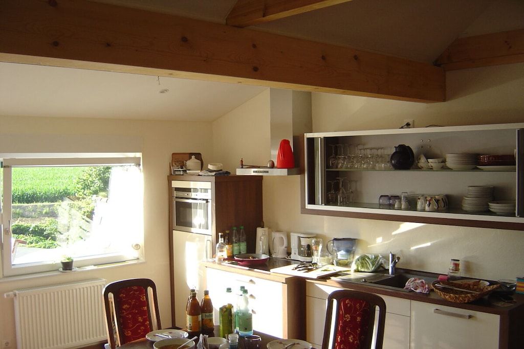 A kitchen with a window, a refrigerator, and various kitchen items.