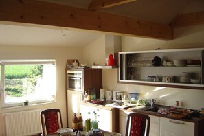 A kitchen with a window, a refrigerator, and various kitchen items. - Holiday apartment with 3 bedrooms (Fargau-Pratjau)