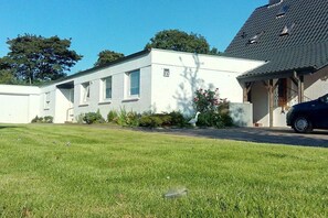 A two-story residential building with a white exterior, a visible number '35' on the side, and a car parked in the driveway. - Holiday home in the North Sea with 3 bedrooms (Wilhelmshaven)
