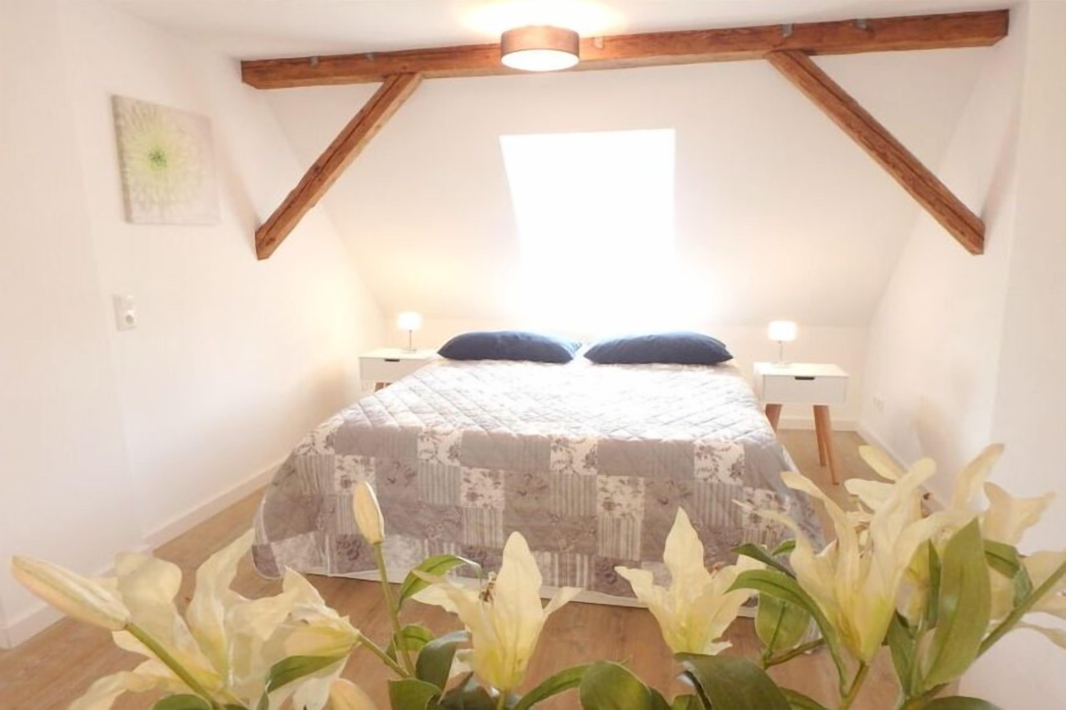 Ein Schlafzimmer mit einem Bett, zwei Nachttischen und einem Fenster.