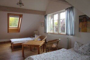 A room with two beds, a table, and a window with curtains. - Holiday home in Born with swimming pool (Born)