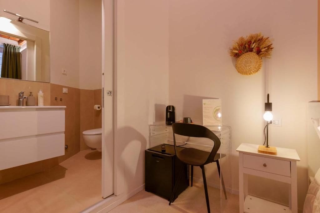 Un baño pequeño con inodoro, lavamanos y una silla.