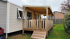 A mobile home with a porch, a ramp, and a fenced area. - Rent a mobile home (Saint-Hilaire-de-Riez)