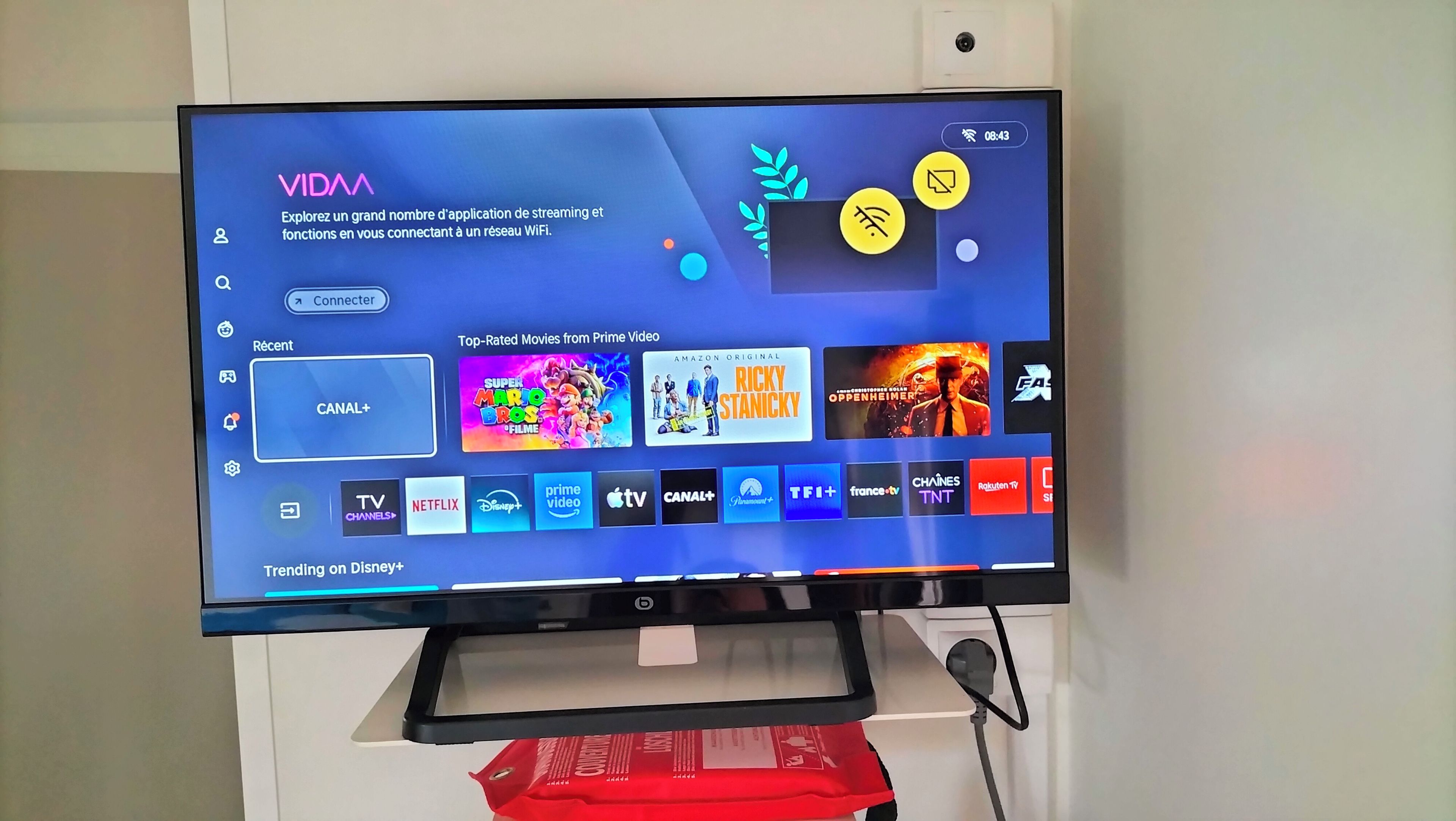 A television displaying a streaming service interface with various movie options and a 'Trending on Disney+' section.
