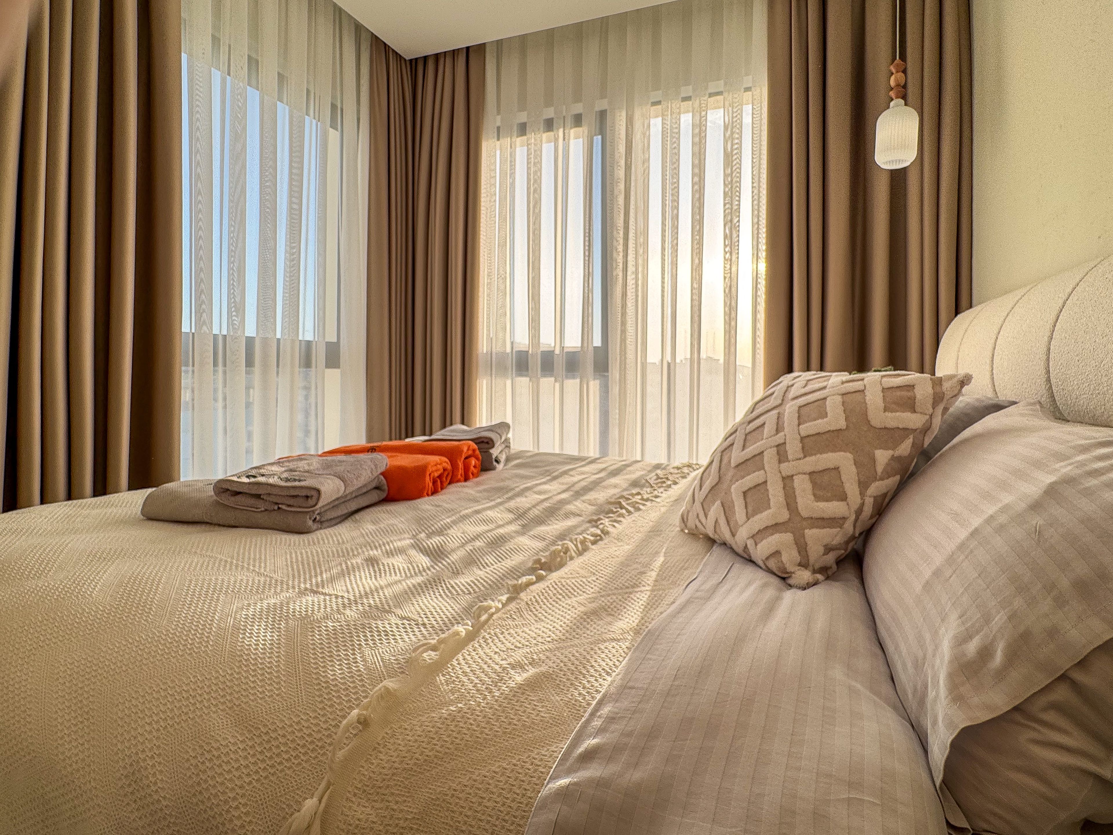 Une chambre d’hôtel avec un lit, des rideaux et une fenêtre équipée de stores.
