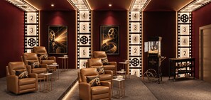 Ein kino-inspiriertes Zimmer mit Ledersesseln, einem Popcornewagen und Wanddekorationen mit Filmstreifen.