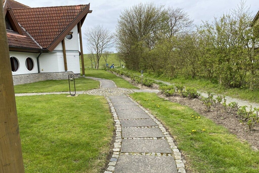 Un sendero de piedra que conduce a un edificio con techo de tejas.
