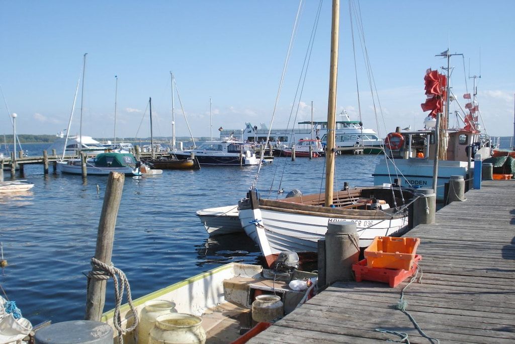 Un port de plaisance où des bateaux sont amarrés à des quais en bois.